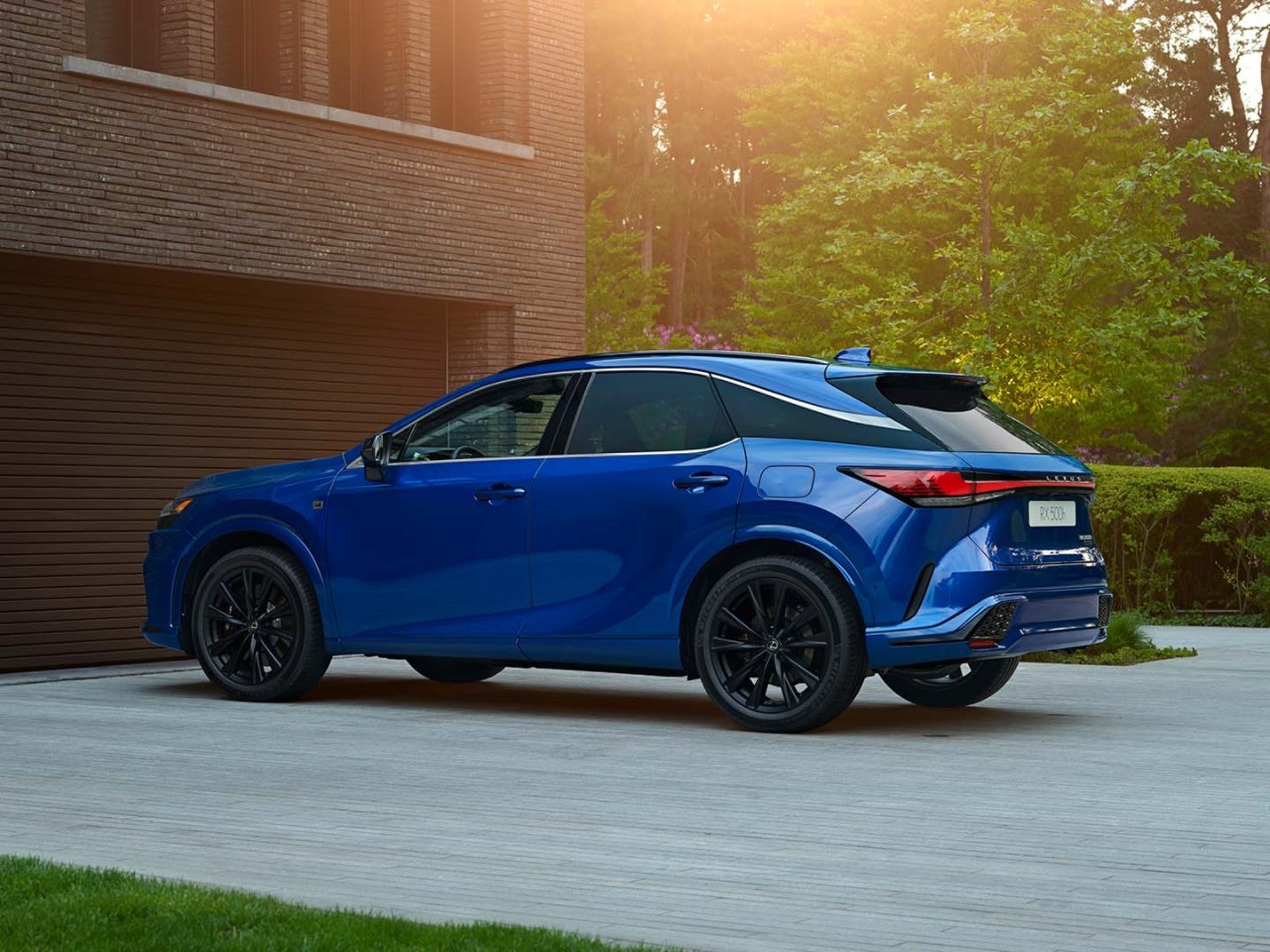 Side view of the Lexus RX 500h parked on a driveway.